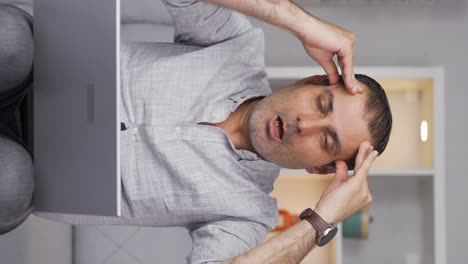 Vertical-video-of-Man-working-on-laptop-has-a-headache.